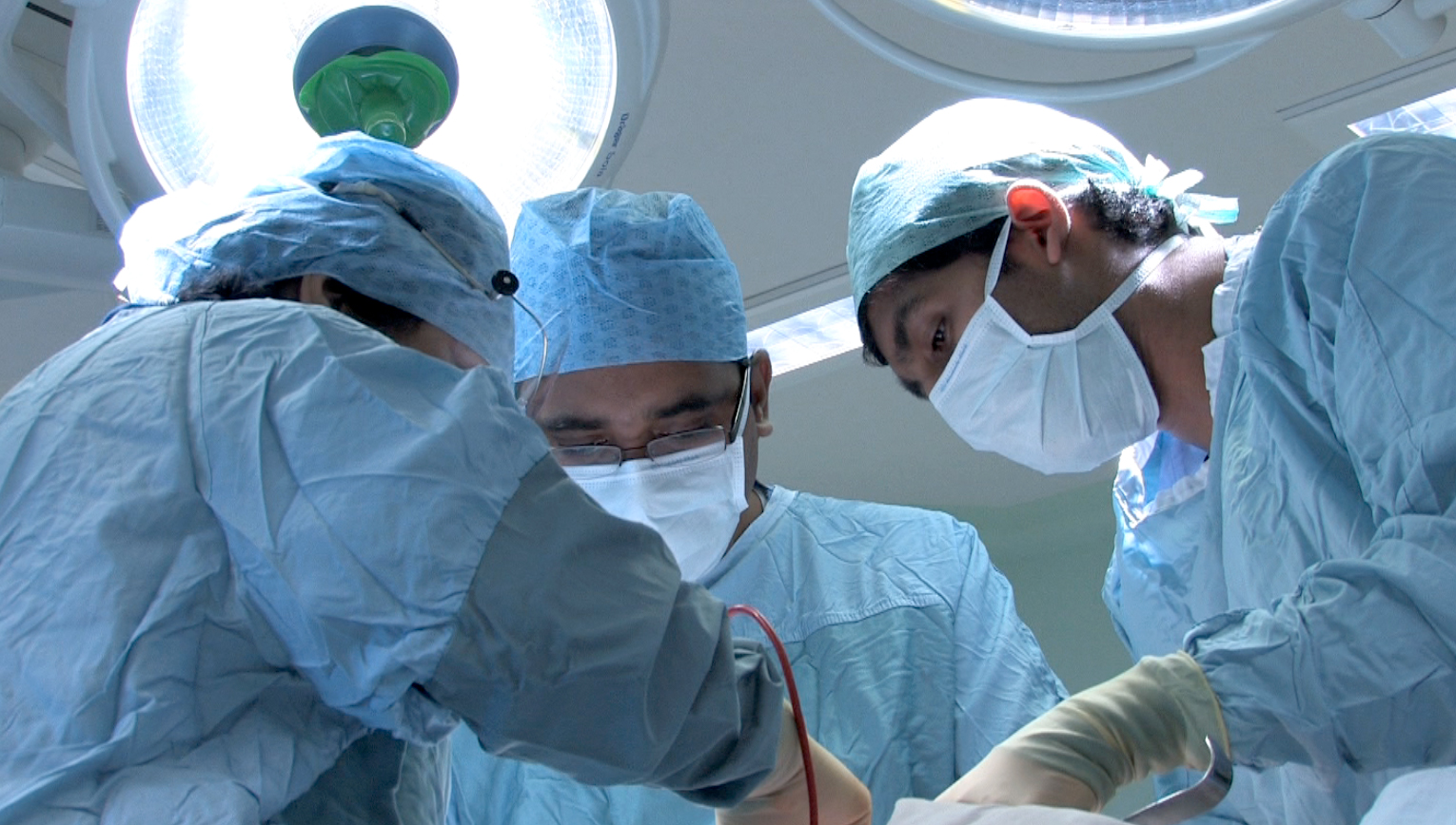 Surgeons performing a medical procedure in theatre